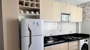 Eine moderne Küche mit integriertem Kühlschrank, Herd, Mikrowelle und Waschmaschine.