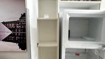 Un refrigerador entreabierto con estantes y un compartimento congelador.