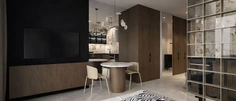 A modern hotel room with a large bed, a round dining table, and a TV mounted on the wall.