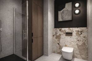 A modern bathroom with a glass shower enclosure, a wooden cabinet, a marble wall, and a toilet. - Amaretto by Kairos Apartments (Gliwice)