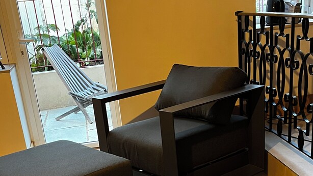 Et moderne loungeområde med en sofa, et lille bord og en dekorativ genstand på bordet.