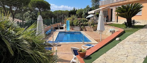 Ein Schwimmbecken mit Liegestühlen und einer Steinterrasse.