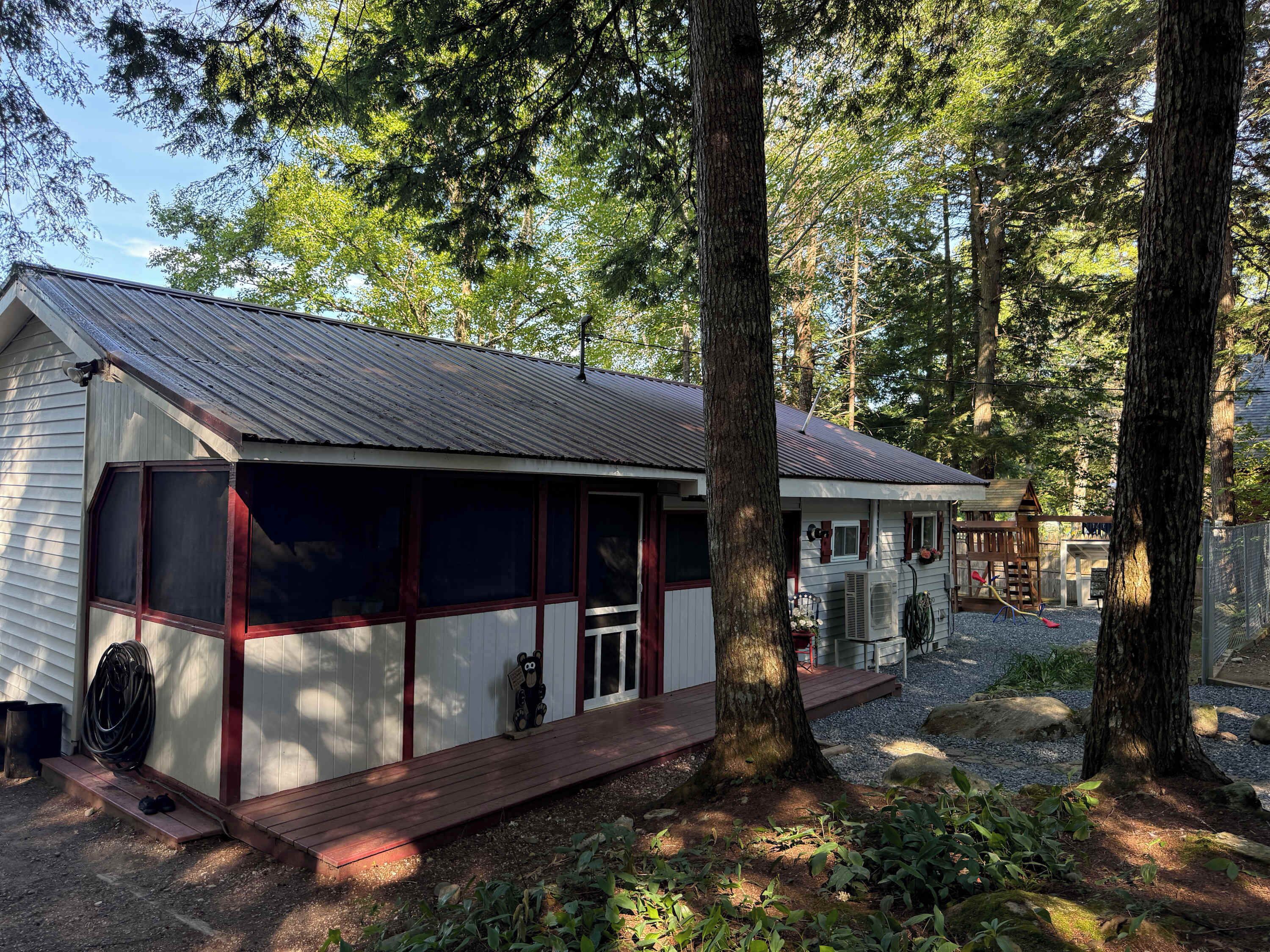 A cabin with a porch, surrounded by trees.
