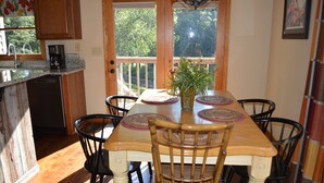 Un coin repas avec une table en bois, des chaises et un vase de fleurs.
