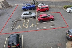 A parking lot with marked disabled parking spaces and a red boundary line. - Central Derby 2-Bed | Arcade, Free Parking, King Bed & Ultrafast Wi-Fi (Derby)