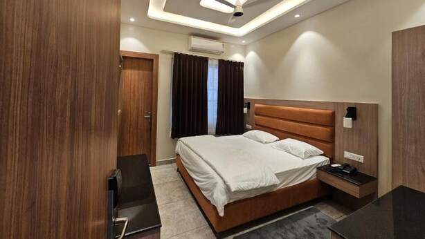 A modern hotel room with a bed, bedside table, and a ceiling fan.