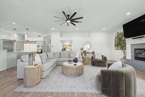 A modern living room with a sectional sofa, a round coffee table, and a fireplace. - 4BR Scottsdale Getaway with Pool, Spa & Game Room (Scottsdale)