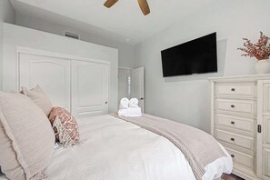 A bedroom with a bed, a dresser, a television, and a door. - 4BR Scottsdale Getaway with Pool, Spa & Game Room (Scottsdale)