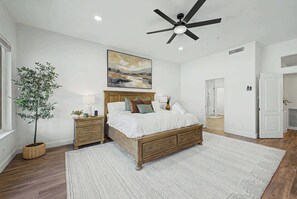 A bedroom with a bed, bedside tables, a ceiling fan, a painting, and a potted plant. - 4BR Scottsdale Getaway with Pool, Spa & Game Room (Scottsdale)