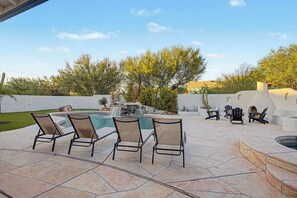 An outdoor patio with a pool, lounge chairs, and a waterfall feature. - 4BR Scottsdale Getaway with Pool, Spa & Game Room (Scottsdale)