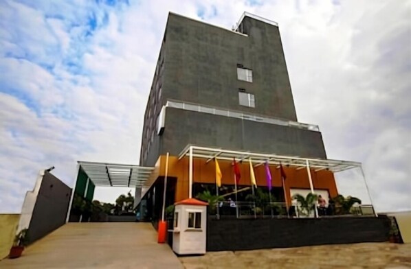 A modern building with a flat roof, a covered entrance area, and a small adjacent structure.