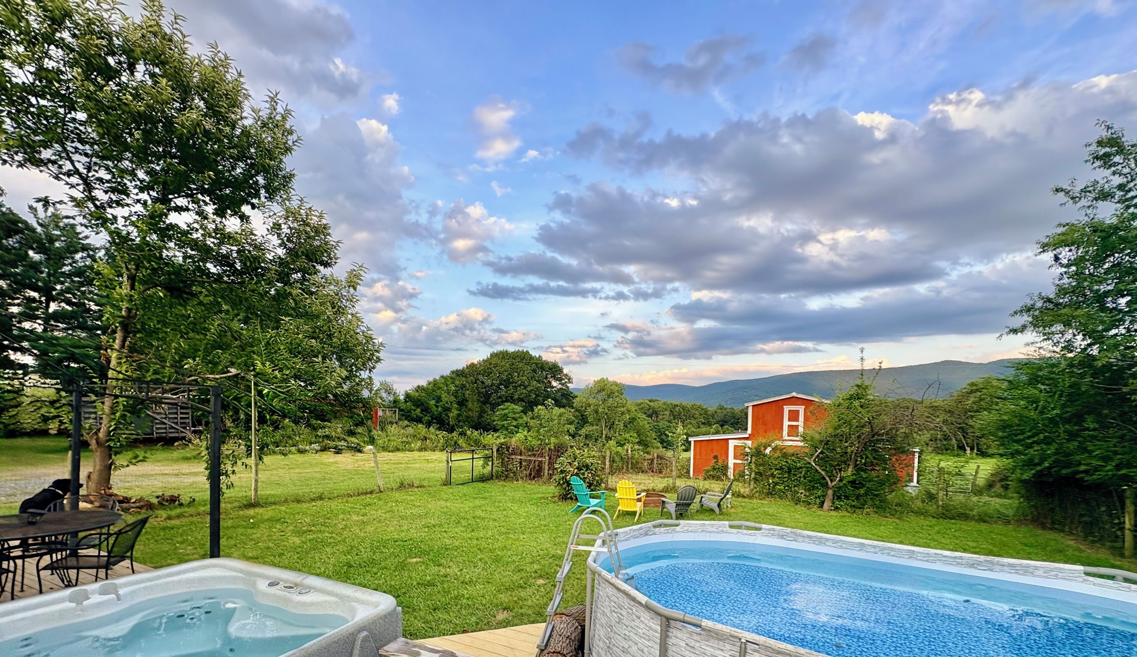 Un jardin avec une piscine, un jacuzzi et un espace repas aménagé avec du mobilier d’extérieur.