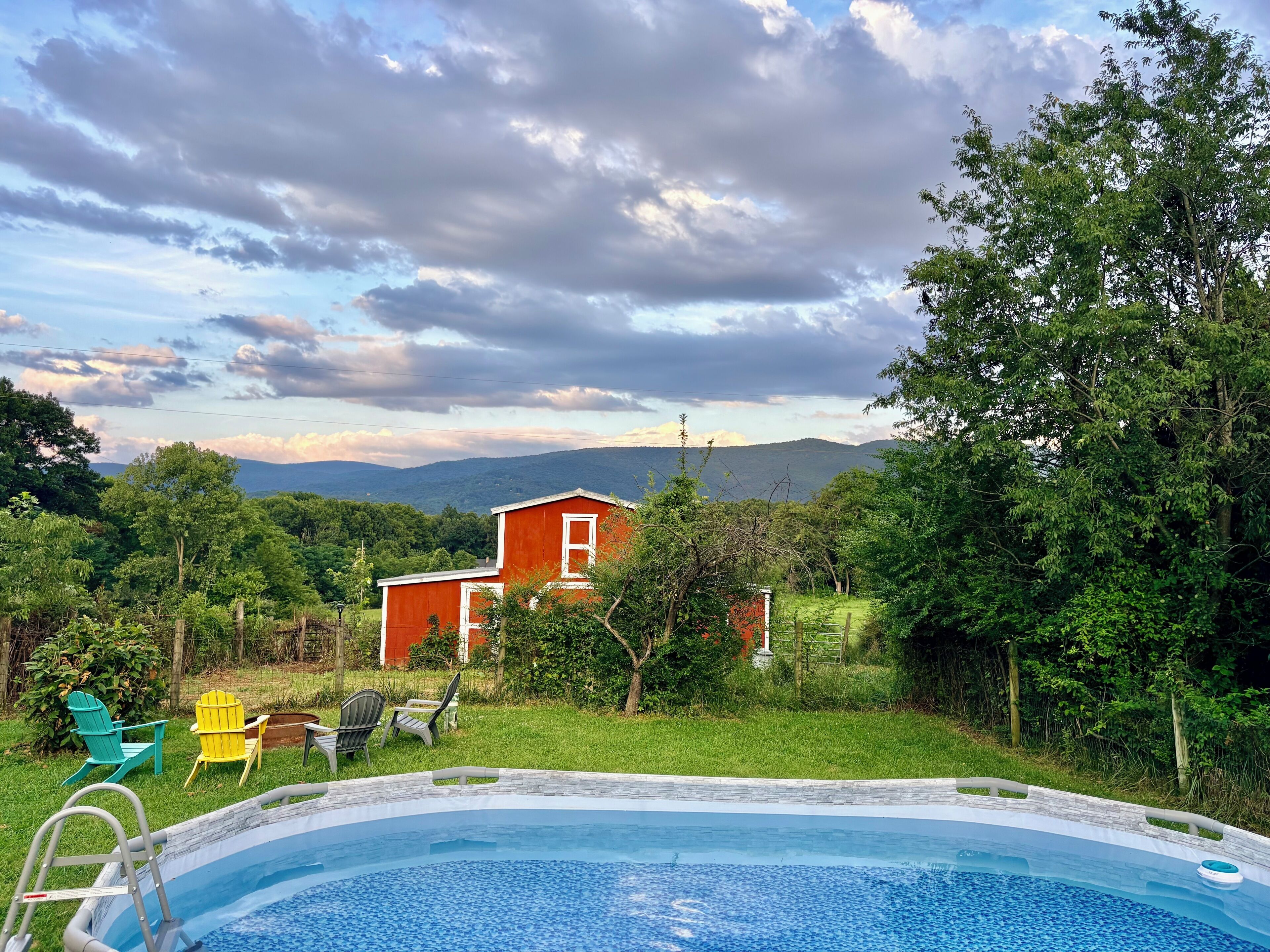 A swimming pool with a view of a house and mountains in the background.