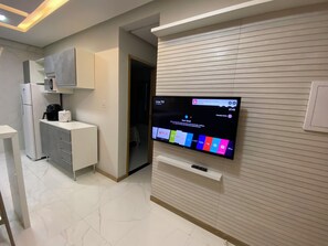 A modern kitchen with a built-in TV displaying various streaming services. - 307 2Qtos Funcional bem Localizado (Belém)
