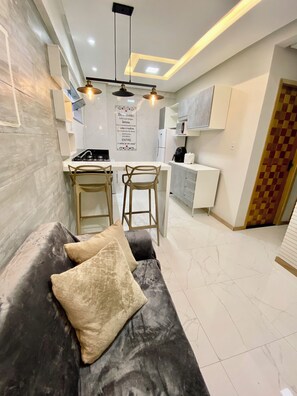 A modern kitchen with a dining area, a sofa with cushions, and a checkered door. - 307 2Qtos Funcional bem Localizado (Belém)