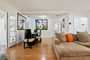 A modern living room with a beige sofa, a dining table with chairs, and a large painting on the wall. - Charming 4bed 3bath piano home in Los Angeles by Universal Studio & Hollywood-10 (los angeles)