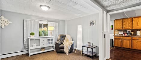 Une pièce comprenant un canapé, une lampe, une petite table et un élément décoratif mural.