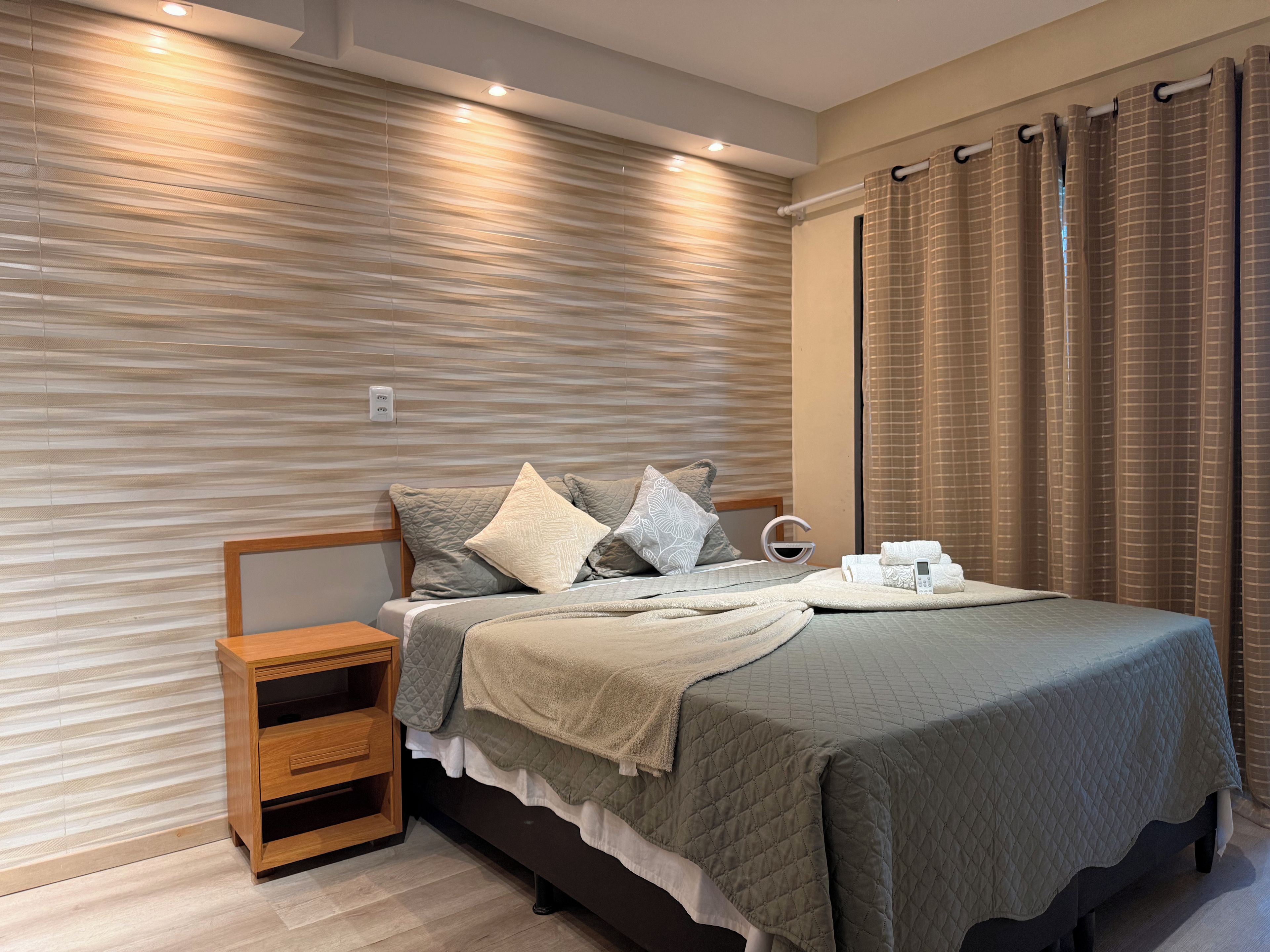 A modern bedroom with a bed, bedside table, and a nightstand.
