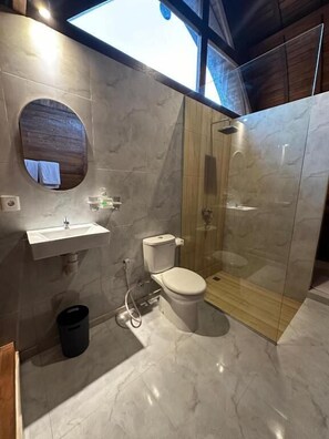 Ein modernes Badezimmer mit Duschkabine aus Glas, Toilette und Waschbecken.