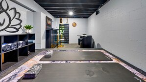 A gym with a mirrored wall, exercise mats, and a foosball table. - Mountain Views | EV Charger | Pool | Speakeasy (Broken Bow)
