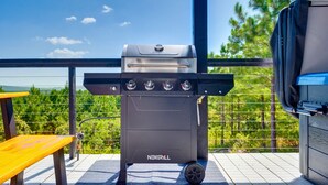 A NEXGRILL barbecue grill on an outdoor deck with a view of trees and a clear sky. - Mountain Views | EV Charger | Pool | Speakeasy (Broken Bow)