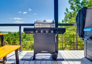 A NEXGRILL barbecue grill on an outdoor deck with a view of trees and a clear sky. - Mountain Views | EV Charger | Pool | Speakeasy (Broken Bow)