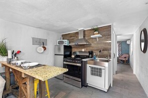 A compact kitchen with a wooden countertop, stainless steel appliances, and a small dining area. - Double Waterfront Estate; 12 Beds, Kayaks, Firepit (Tampa)