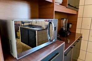 A kitchen with a microwave, a blender, and a dish rack. - Casa do Curral | A home close to everything! (Ilhabela)