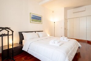 Ein Hotelzimmer mit Bett, Nachttisch, Kleiderschrank und einem Bild an der Wand.