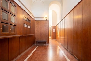A hallway with wooden paneling, a bench, and a light fixture. - Murat Wooden House | Rustic Charm in Central Bari (Bari)