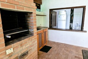 Eine Küche mit Backofen, einem Fenster mit Blick auf einen Küchenbereich und einer Steckdose an der Wand.