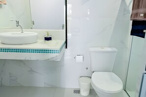 Ein Badezimmer mit weißem Waschbecken, Spiegel und Toilette.