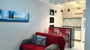A modern kitchen with a marble backsplash, a built-in island, and pendant lighting. - 403 Apto Versátil e Aconchegante (Belém)