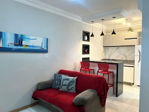 A modern kitchen with a marble backsplash, a built-in island, and pendant lighting. - 403 Apto Versátil e Aconchegante (Belém)