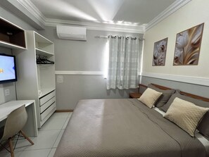 A bedroom with a bed, a desk, and a television. - 403 Apto Versátil e Aconchegante (Belém)