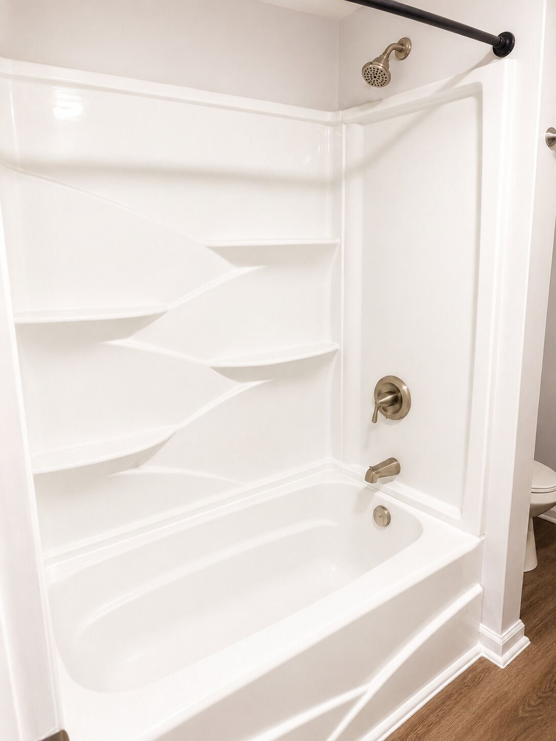 A white bathtub with a showerhead, a faucet, and a control knob.