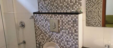 Een badkamer met toilet, wastafel en douche.