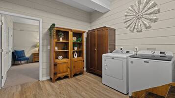 A laundry room with wooden cabinets, a wall-mounted decorative item, and two front-loading washing machines.