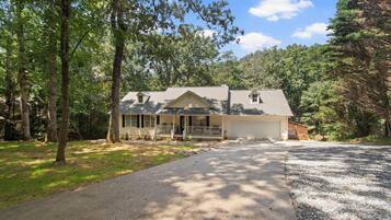 A single-story house with a front porch, a garage, and a driveway.
