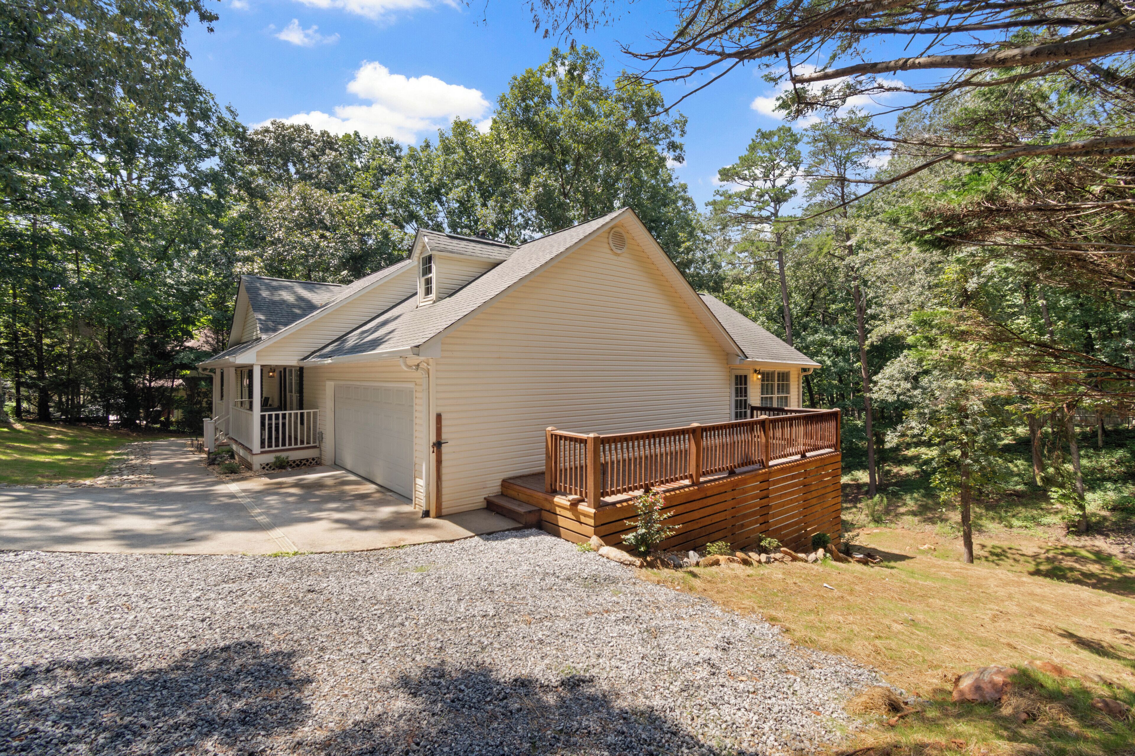 A single-story house with a front porch, a garage, and a wooden deck.