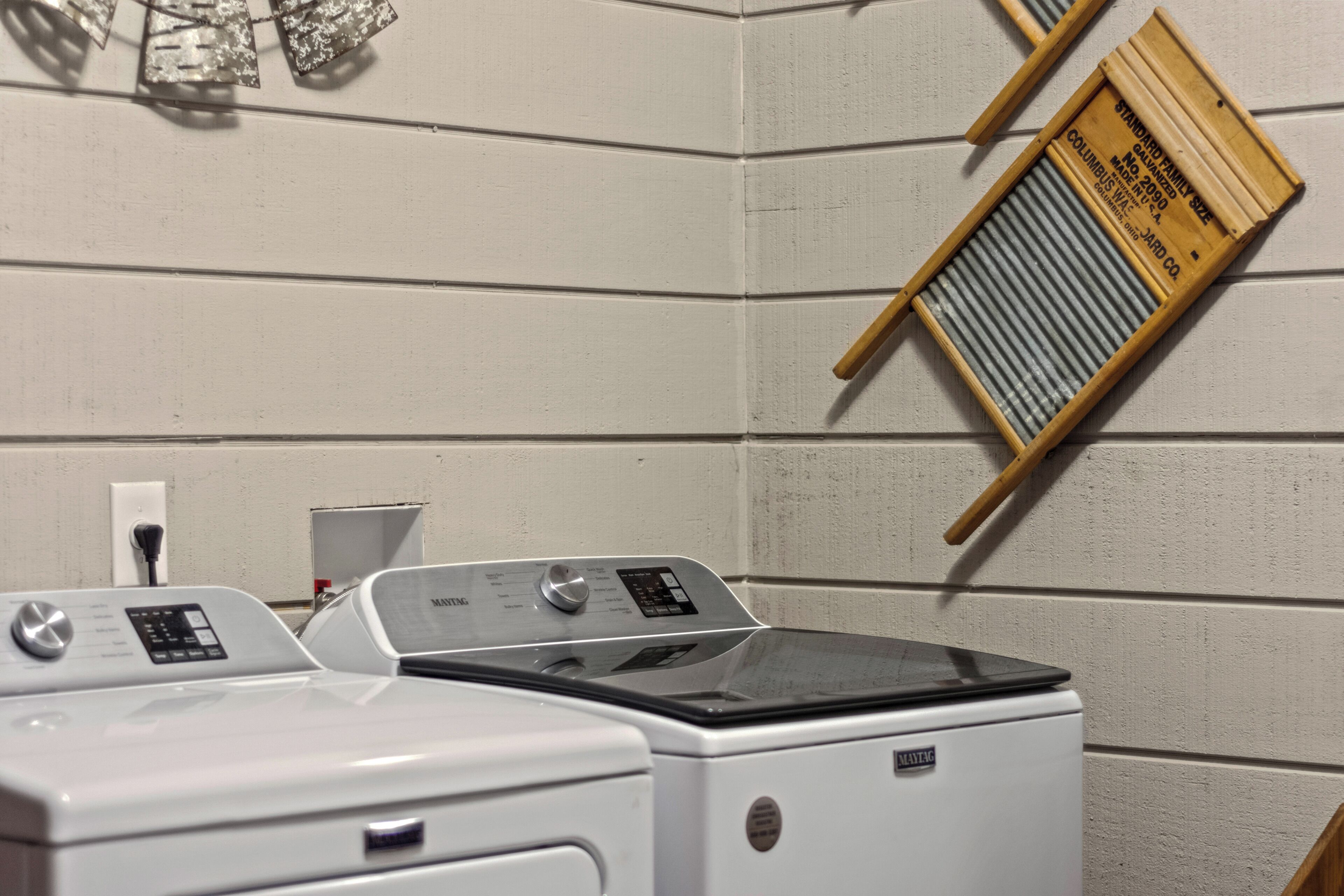 A laundry area with two washing machines and a drying rack.