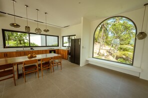 Eine moderne Küche mit großem Fenster, einem Holzespeisetisch und eingebauten Geräten.