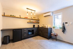 Eine moderne Küche mit schwarzen Schränken, einem eingebauten Ofen und einem Fenster, das für natürliches Licht sorgt.