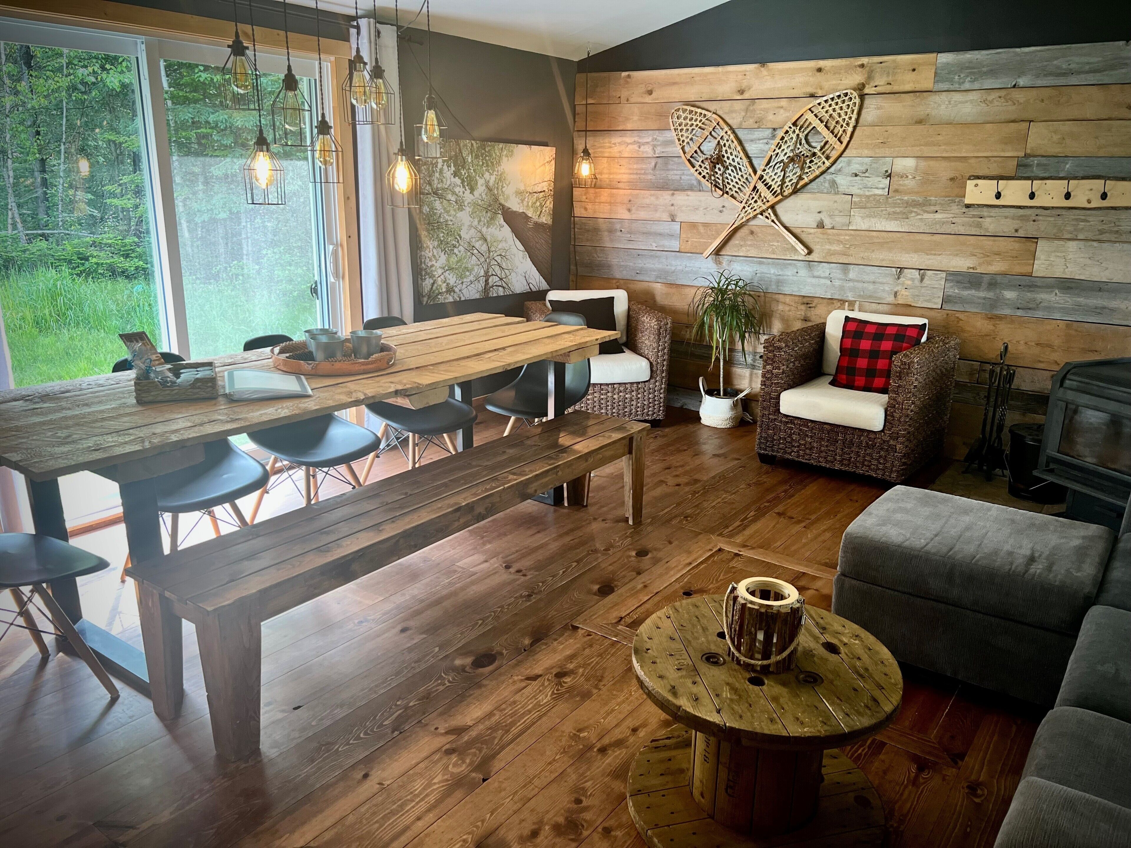 Un ambiente acogedor con una mesa de comedor de madera, sillas, un sofá y una chimenea.