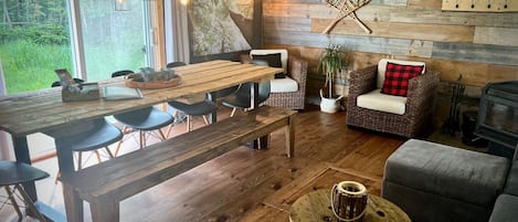 Un ambiente acogedor con una mesa de comedor de madera, sillas, un sofá y una chimenea.