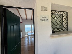 A room with a green door, a window with a metal grille, and a balcony with a view. - Stunning Lake View, Peaceful Green Hillside Setting, 10 Minutes from the Beaches (Toscolano Maderno)