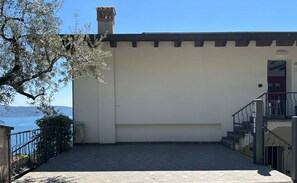 Ein Gebäude mit einer flachen Dachterrasse, einem Schornstein und einer Treppe, die zu einer oberen Ebene führt.