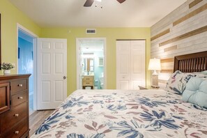 A bedroom with a bed, dresser, and a nightstand with a lamp. - ⛱️Gulf Front | Tiki Hut | Pools | Corner | Pelican Beach Resort 904 (Destin)