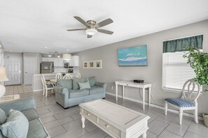A modern living room with a sofa, a coffee table, and a dining area with a table and chairs. - ☀️Maravilla 3208 | Walk 2 Beach | Free beach service | 2 Pools + Hot Tub⛱️ (Miramar Beach)