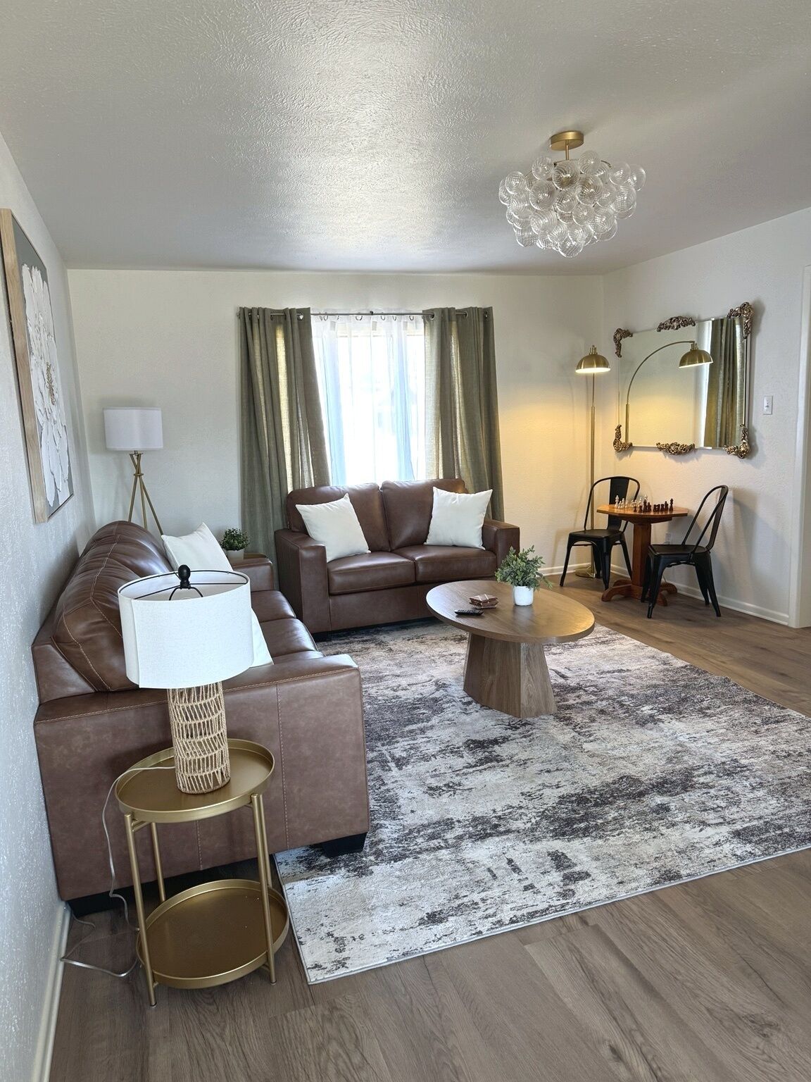 A modern living room with a brown leather sofa, a round coffee table, and a floor lamp.
